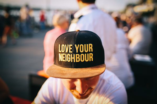 Man wearing hat that says "Love your neighbor"
