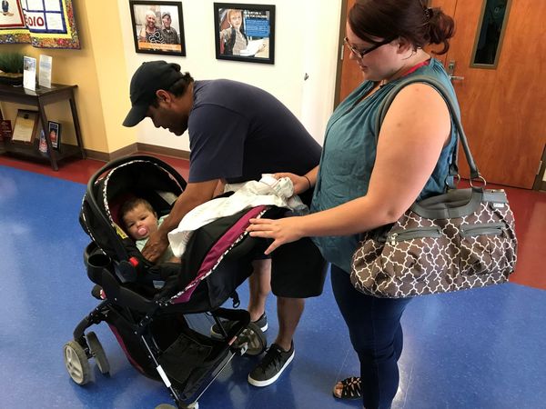 Mom and Dad tending to their baby in her stroller.
