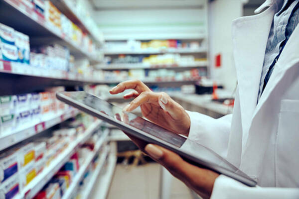 Pharmacist using tablet to inventory medication
