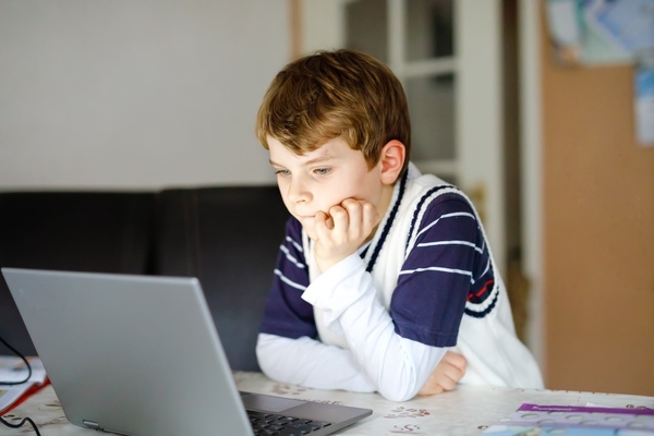 young boy staring at computer screen