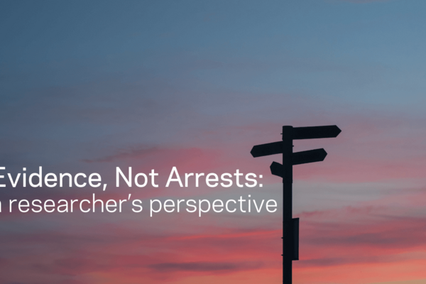 Photo of a sky at sunset with the silhouette of a crossroads sign with text on the image reading "Evidence, Not Arrests: a researcher's perspective"